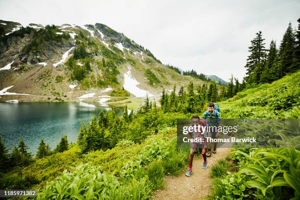 father and son hiking on mountain trail near alpine lake during backpacking trip - 8 muses stock pictures, royalty-free photos & images