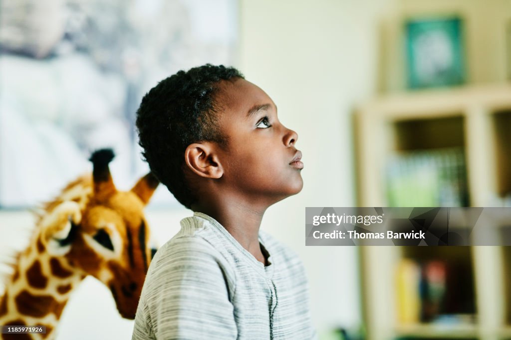 Portrait of young boy in living room of home
