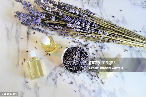aromatic oils with lavender flowers on marble background - lavendel stock-fotos und bilder