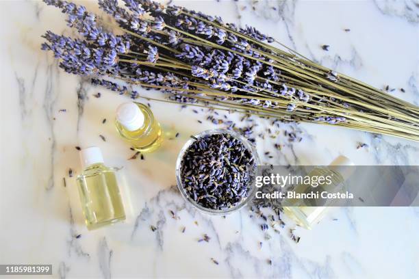 aromatic oils with lavender flowers on marble background - 匂い ストックフォトと画像
