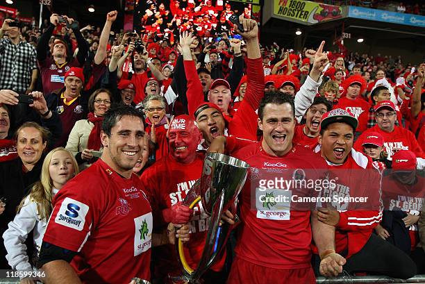 Reds captain James Horwill and team mate Ben Daley celebrate with the trophy after winning the 2011 Super Rugby Grand Final match between the Reds...