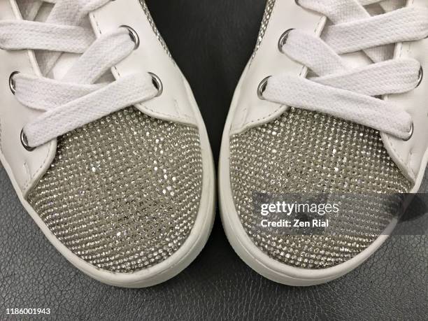 pair of white sneakers with glittering plastic rhinestones on black background - rhinestone photos et images de collection