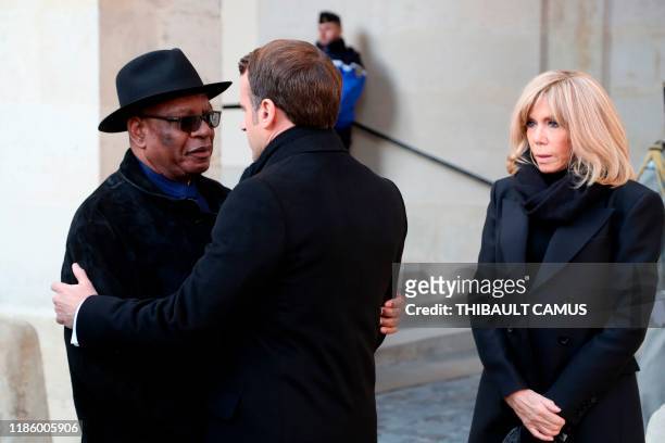 French President Emmanuel Macron hugs Mali's President Ibrahim Boubacar Keita while Brigitte Macron looks on prior a ceremony at the Invalides...