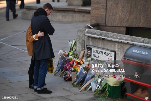 Couple place a bouquet of flowers on London Bridge in memory of the victims of last weeks attack in central London on December 12, 2019.