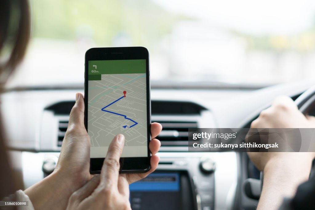 Shot of a young couple using gps on their mobile phone during a road trip.