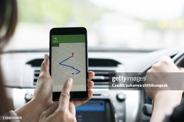 shot of a young couple using gps on their mobile phone during a road trip. - navigatieapparatuur stockfoto's en -beelden