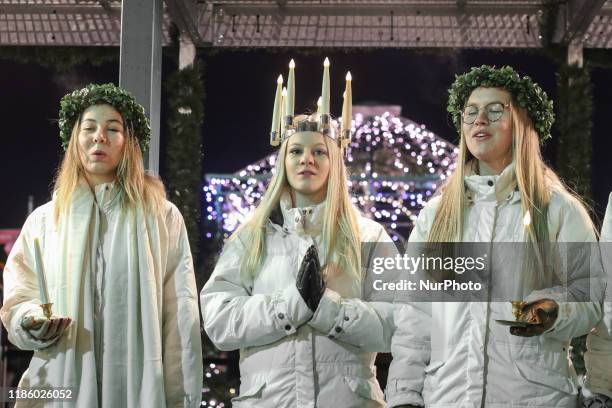 Young girls from Kalmar, Sweden dressed in a white dress and a red sash carries candles in proccesion along the Gdansk Christmas Fair on the Old City...