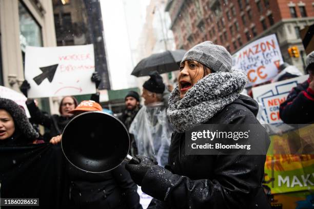 Demonstrator shouts slogans and bangs on a pan outside the penthouse of Jeff Bezos, founder and chief executive officer of Amazon.Com Inc., during a...