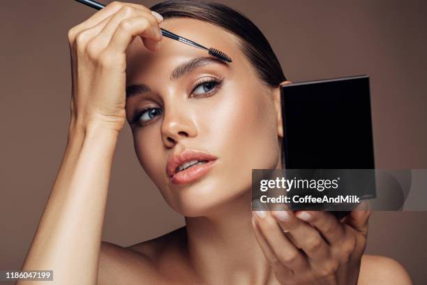 vrouw die make-up toepast - girl in mirror stockfoto's en -beelden
