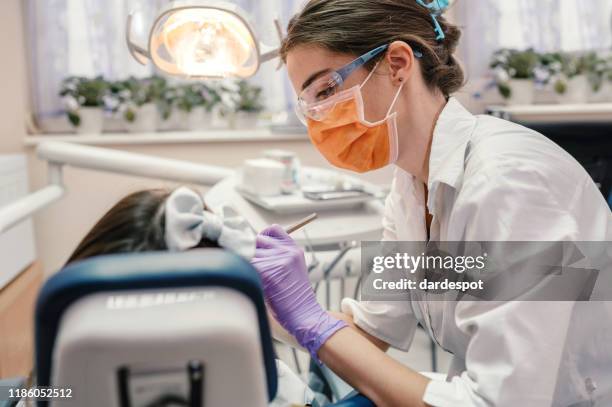 girl receiving dental care - dentist's chair stock pictures, royalty-free photos & images