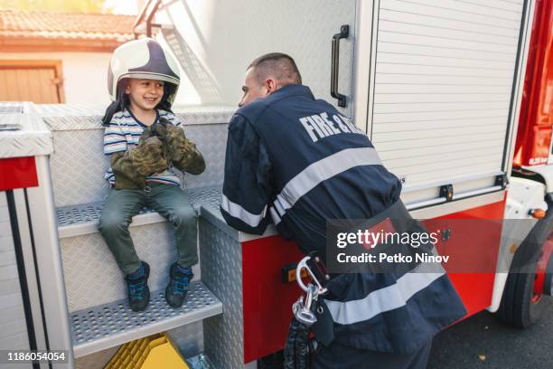 niño feliz visitando a los bomberos - camión de bomberos fotografías e imágenes de stock
