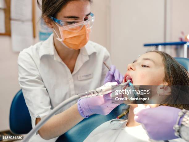 ragazza che riceve cure dentistiche - dentista bambini foto e immagini stock