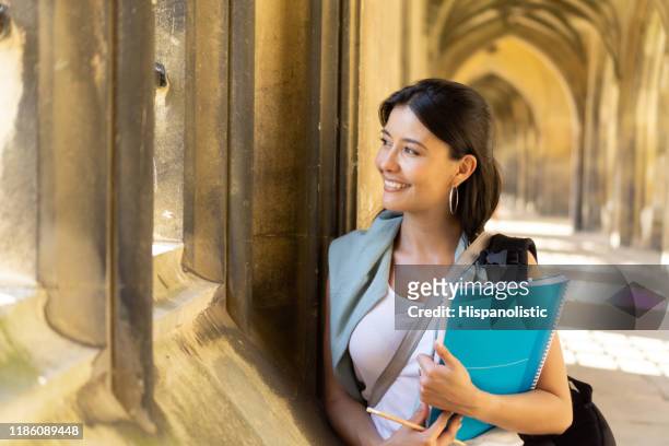 nachdenkliche studentin sieht sehr glücklich an der universität - cambridge england stock-fotos und bilder