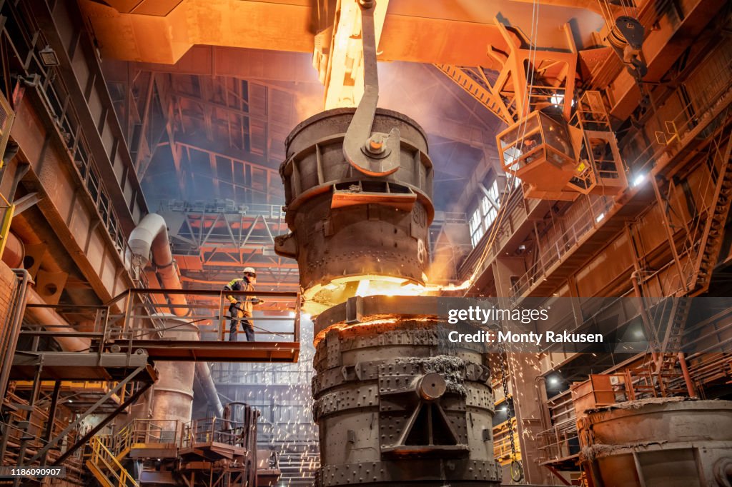 Steelworker starting molten steel pour in steelworks