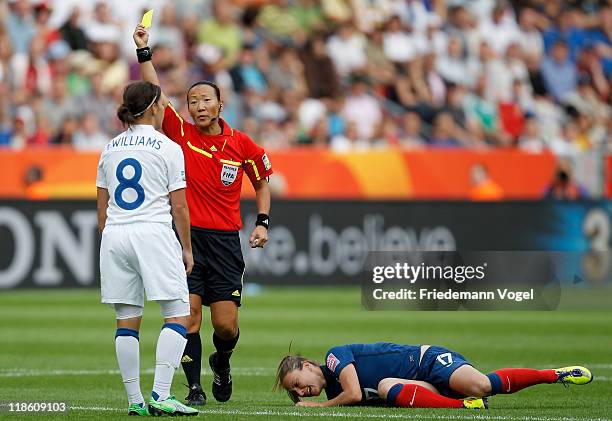 Referee Jenny Palmqvist of Sweden shows Fara Williams of England the yellow card after a foul on Gaetane Thiney of France during the FIFA Women's...