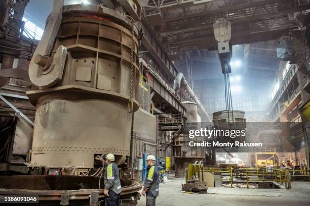 workers preparing molten steel ladle in steelworks - worker inspecting steel foto e immagini stock