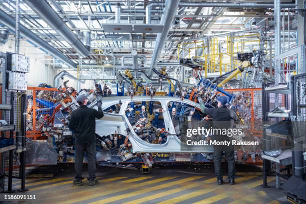 workers loading car body spot welding machine with robots in car factory - the human body ストックフォトと画像