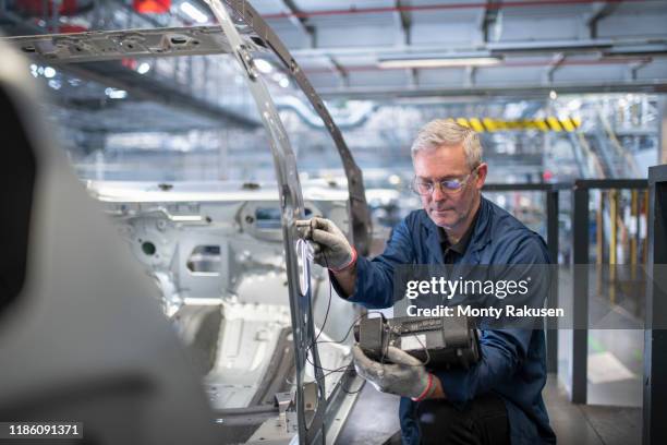 engineer testing car body in car factory - automobile industry photos et images de collection