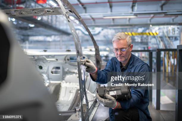 engineer testing car body in car factory - 試車 個照片及圖片檔