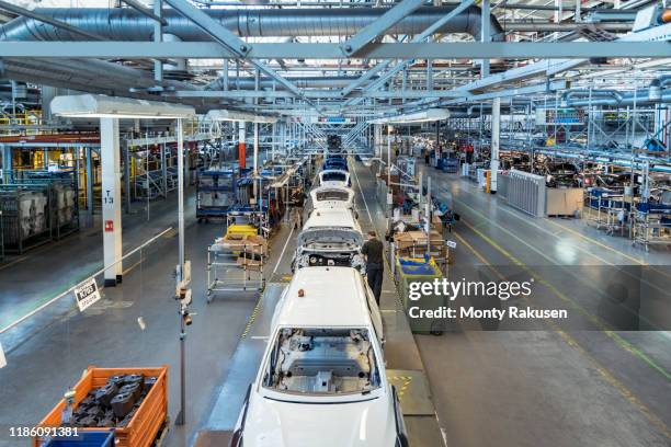 workers on car production line in car factory - car exterior rear high angle stock-fotos und bilder