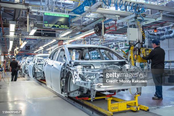 workers on car production line in car factory - production line fotografías e imágenes de stock