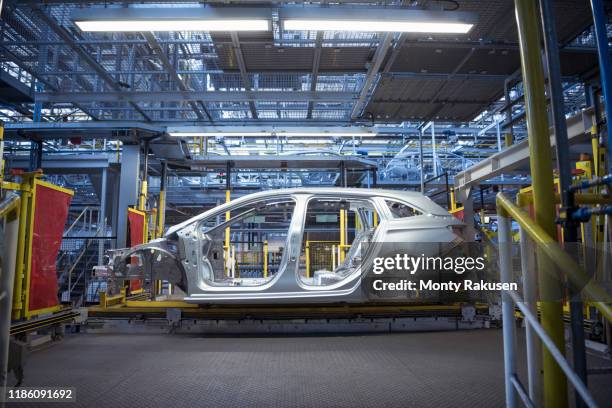 car body on production line in car factory - carrosserie stockfoto's en -beelden