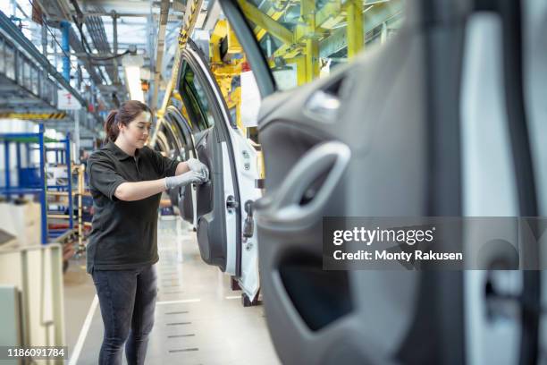 female apprentice engineer assembling car doors in car factory - garment factory stock pictures, royalty-free photos & images