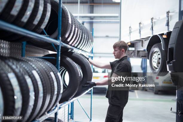 apprentice engineer selecting tyres in car service centre - car wheels stock pictures, royalty-free photos & images