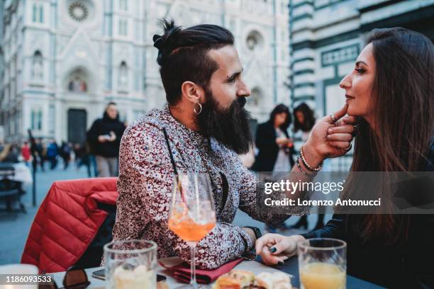 man tenderly touching chin of woman in cafe, santa maria del fiore, firenze, toscana, italy - mimosa fiore fotografías e imágenes de stock