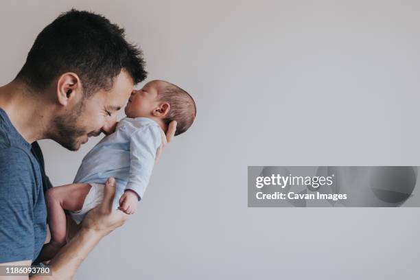 close-up portrait of happy young father hugging her baby - dad newborn stock pictures, royalty-free photos & images