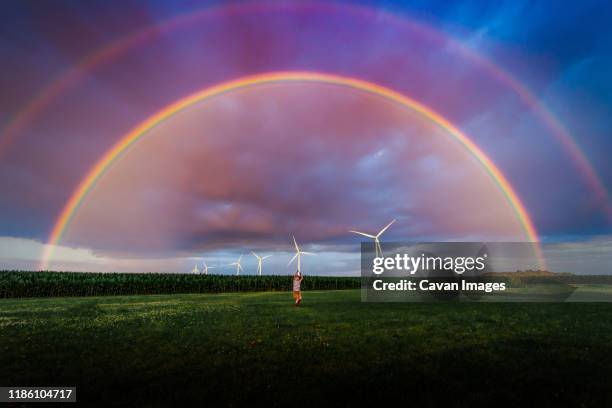 a small boy in a yard with a double rainbow - rural iowa stock pictures, royalty-free photos & images