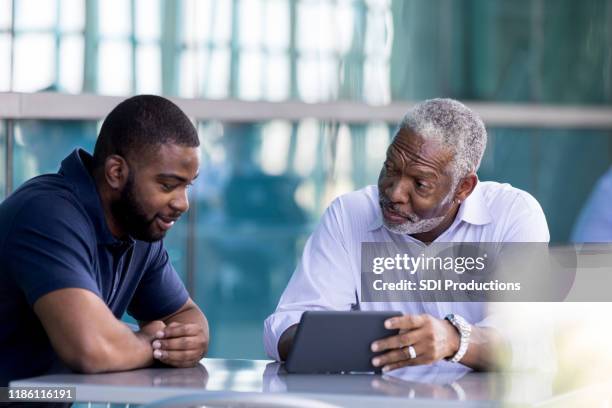 senior businessman meets with male colleauge - dad advice stock pictures, royalty-free photos & images