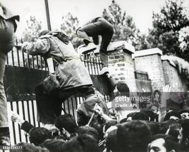 Assaillants escaladant les grilles au début de la prise d'otages de l'ambassade des Etats-Unis à Téhéran, le 4 novembre 1979, Iran.