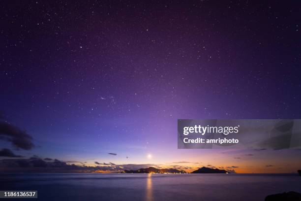 moonlight blues, starry sky over island and ocean - dusk stars stock pictures, royalty-free photos & images