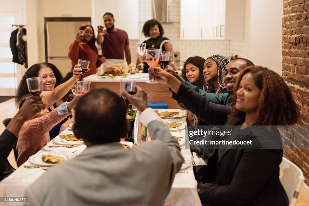 Family cheering enjoying Thanksgiving dinner.