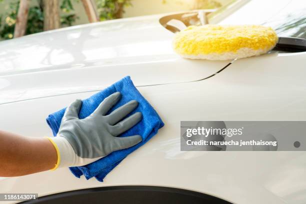 car detailing - the man holds the microfiber in hand and polishes the car. selective focus. - wax strip stock pictures, royalty-free photos & images