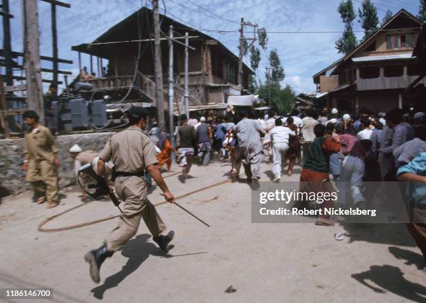 Police officer chases away a crowd after a Kashmiri separatist rally , on the outskirts of Srinagar, India, August 27, 1996. Geelani is a leader of...