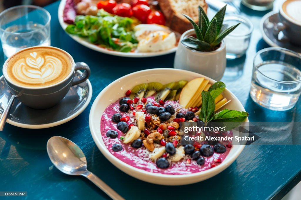Close up of healthy breakfast with acai bowl, fresh berries and fruits