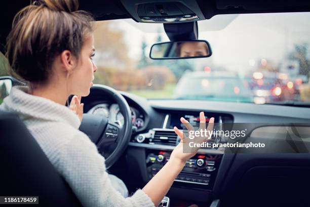 frustrated young girl is waiting in the traffic jam in a rainy day - bottleneck stock pictures, royalty-free photos & images