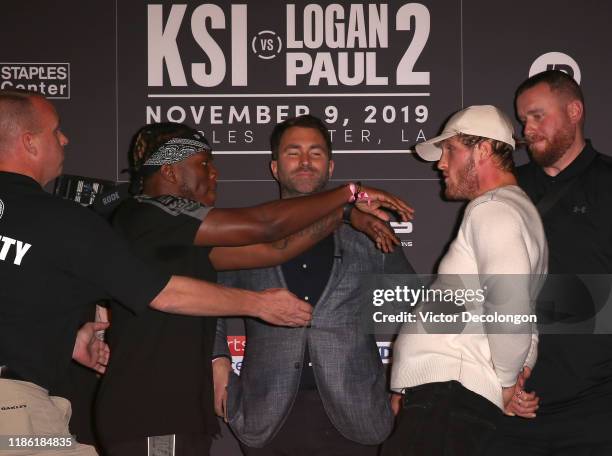 And Logan Paul face off onstage while promoter Eddie Hearn looks on during the KSI VS. Logan Paul 2 - Final Press Conference at TAO Hollywood on...