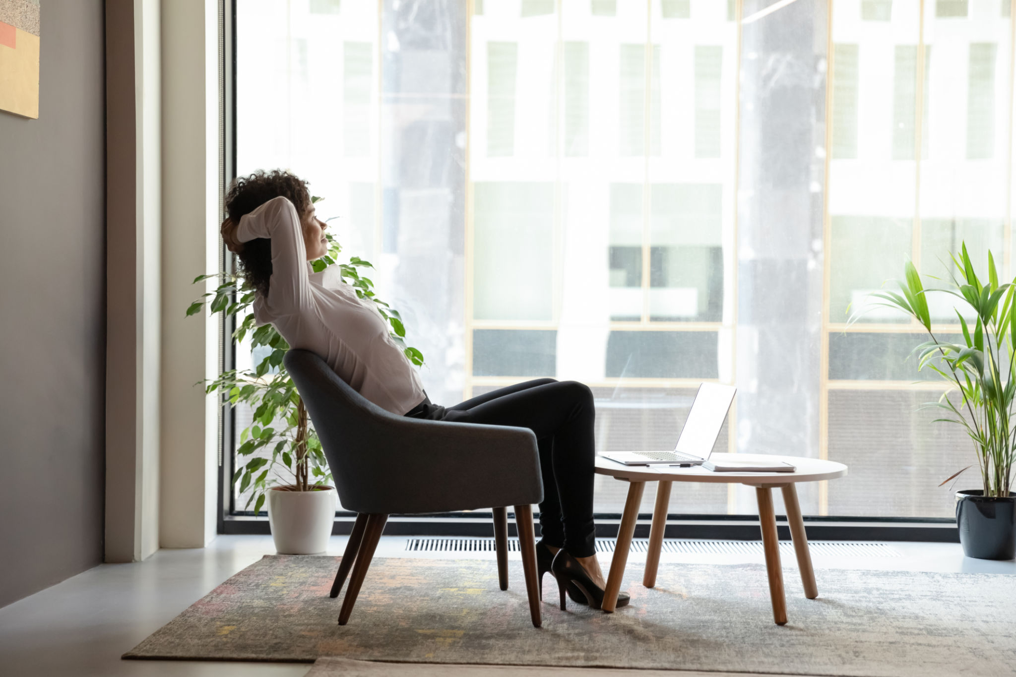 Serene african businesswoman resting sitting on armchair in office lobby Serene african businesswoman resting sitting on armchair in office lobby
