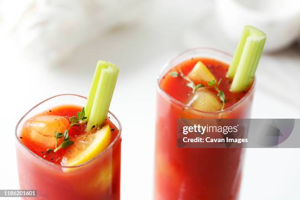 high angle view of bloody mary served with lemon and celeries on table - bloody mary stock pictures, royalty-free photos & images