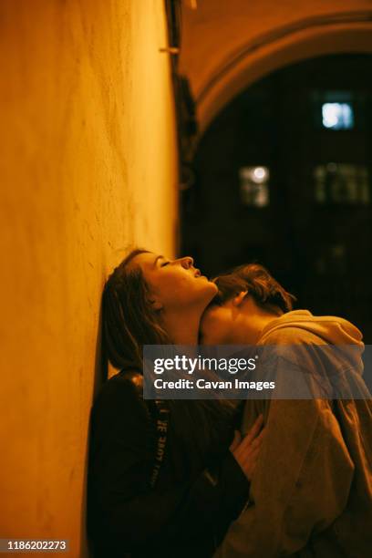 woman kissing girlfriend in city during night - photos of lesbians kissing stock pictures, royalty-free photos & images