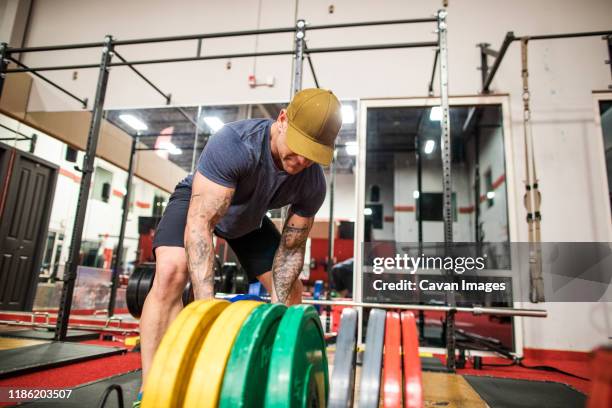 bodybuilder selects weights in preparation for squat exercise - elite athlete stock pictures, royalty-free photos & images