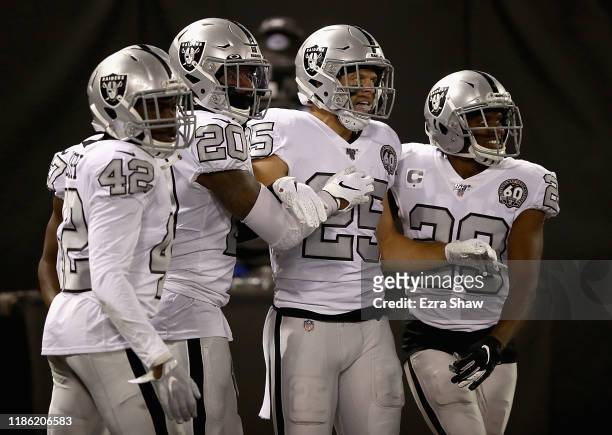 Free safety Erik Harris of the Oakland Raiders and teammates celebrate his interception return for a touchdown in the first quarter over the Los...