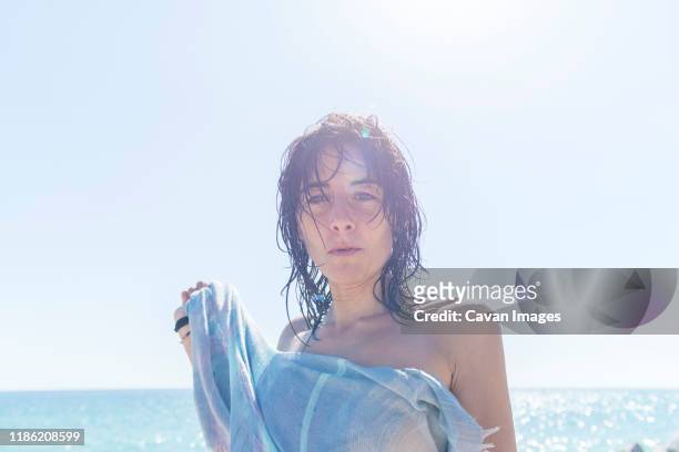 close-up of a young woman covered with a towel while looking camera - hot spanish women ストックフォトと画像