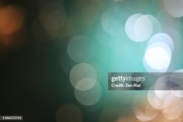 light orbs from defocused christmas decorations on greenish background - flouté photos et images de collection