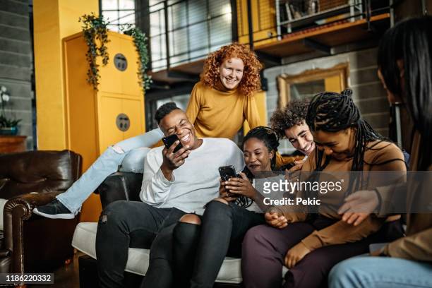 fröhliche multiethnische gruppe von mitbewohnern, die spaß haben - freunde couch stock-fotos und bilder