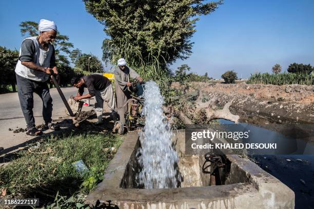 Egyptian farmer Mohamed Omar supplies his farmland with water from a canal, fed by the Nile river, in the village of Baharmis on the outskirts of...