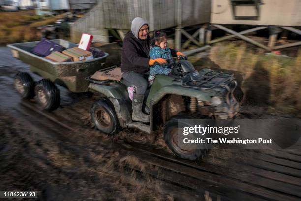 Pauly Andy transports people and belonging using an all-terrain vehicles in Newtok, Alaska where melting permafrost, sinking tundra and flooding...